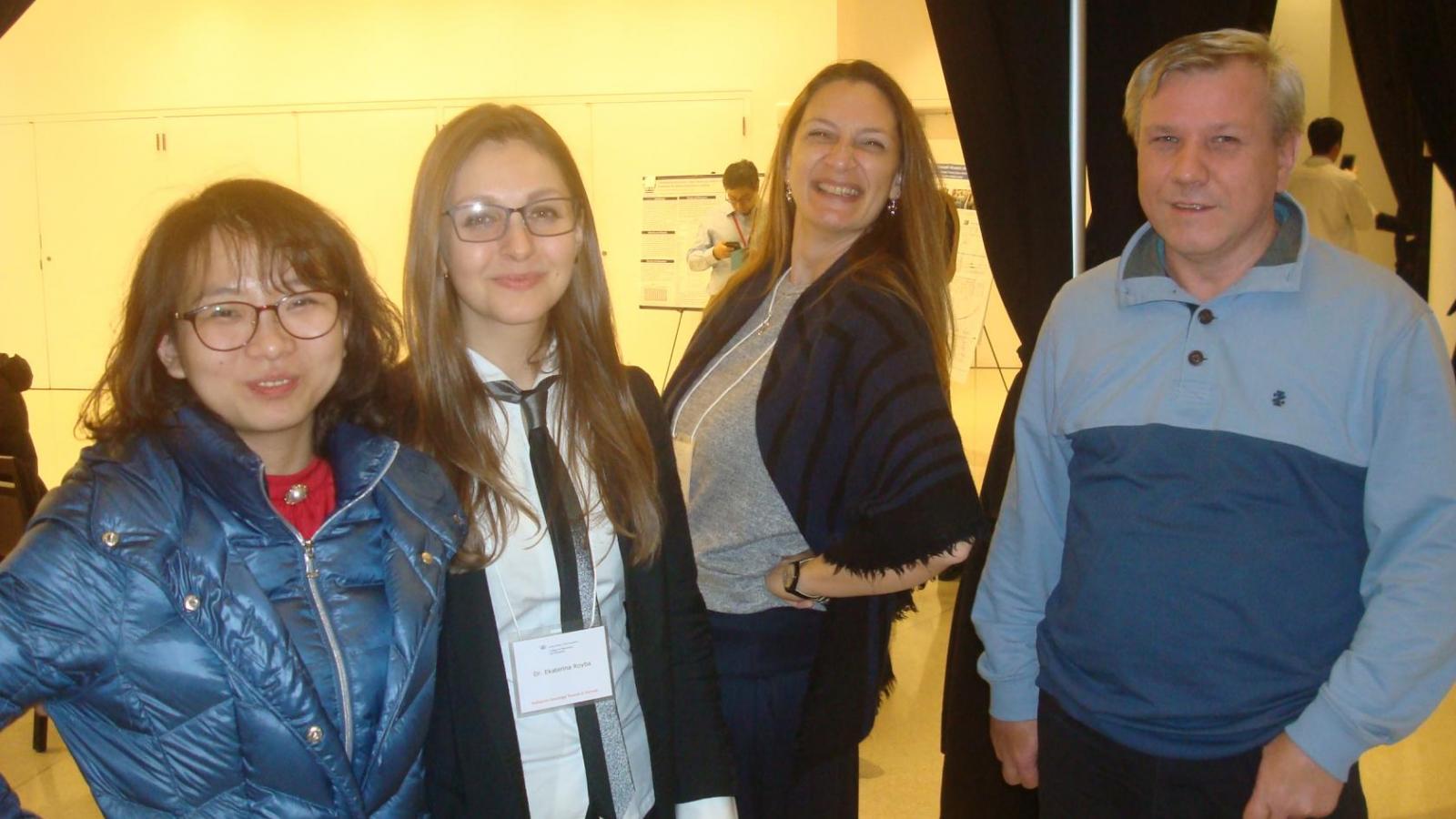 4 doctors pose for picture during poster session at a research retreat