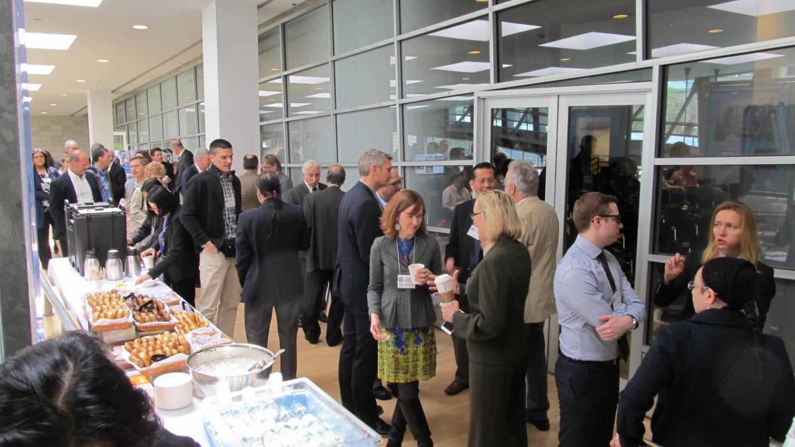 Group of people standing and talking while refreshments are served