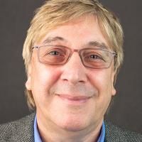 Head shot of man wearing glasses and blue dress shirt